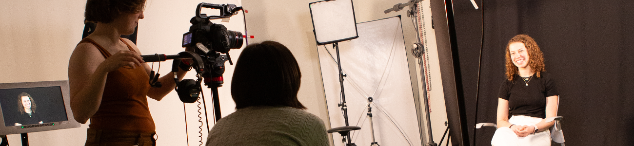 Two people recording and interviewing a third person in the production room