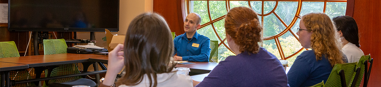 A Research and Instruction Librarian leads a small class session in the Brown Board Roomm
