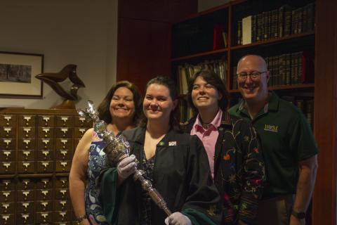 A graduate and family holding the mace 
