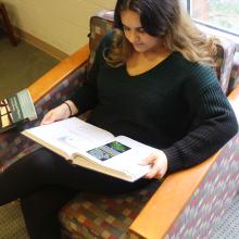 Student reading a textbook in Swem