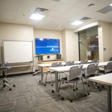 Kyle Classroom with white desks, large screen and whiteboard