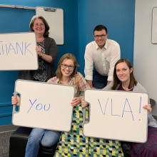 Liz Bellamy and colleagues holding signs that read "Thank you VLA!"
