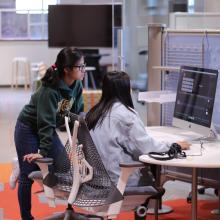 Two students work together at a workstation in the Reeder Media Lab