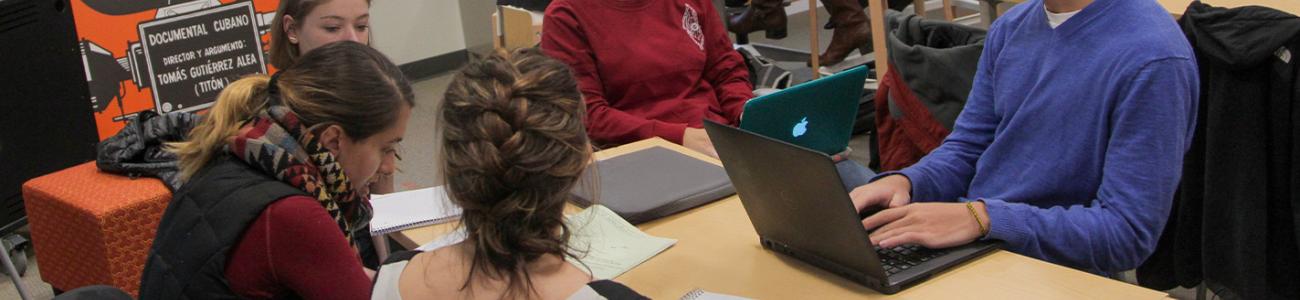 Four students working together at a desk in the Reeder Media Center