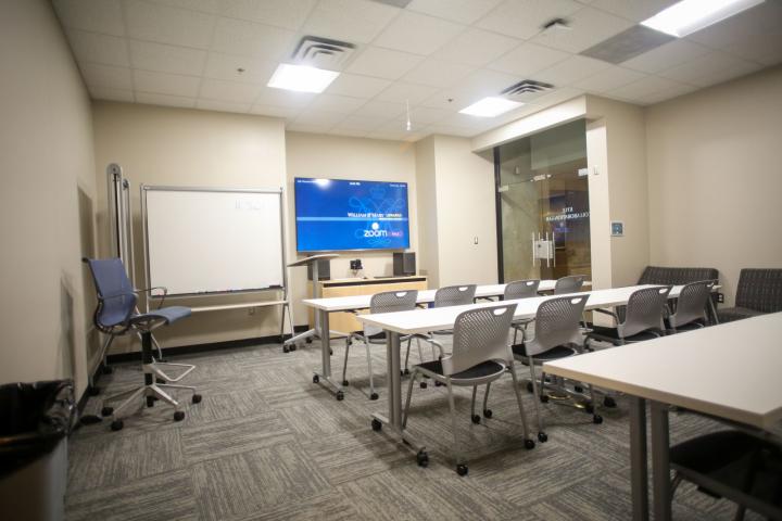 Kyle Classroom with white desks, large screen and whiteboard
