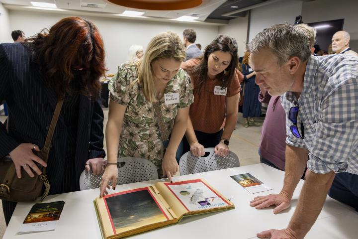 Attendees looking at Glenna's scrapbook