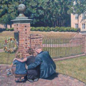 Three people seated at a wreath at the Sunken Garden entrance