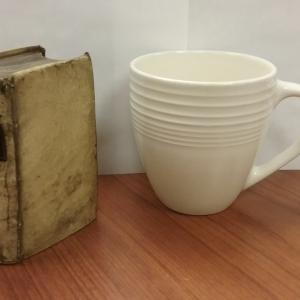 A textbook and mug of the same height are shown together for scale