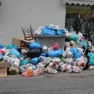 Piles of bagged trash line the street