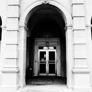 A large arch frames the door to a building