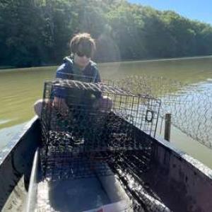 Person on a small boat with a fishing cage