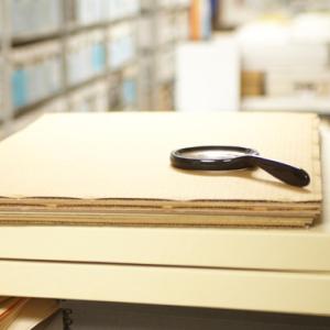Magnifying glass on top of archived papers