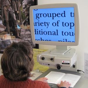 Student uses a text magnifier to enlarge the text of a book onto a screen