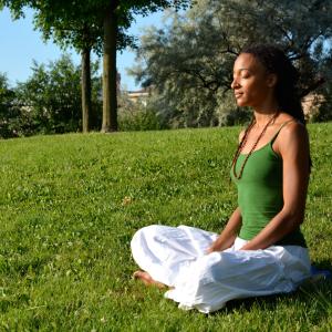 Person seated on grass in a meditation pose