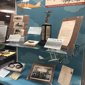 Exhibit case featuring photographs and objects from flight school