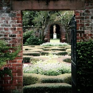 A brick archway frames a formal garden