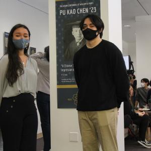 Two students in front of the exhibit banner