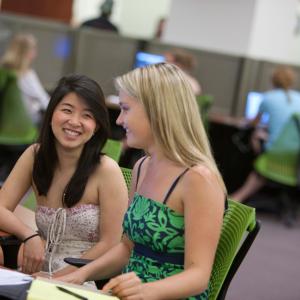 Two students working together in Swem's info commons