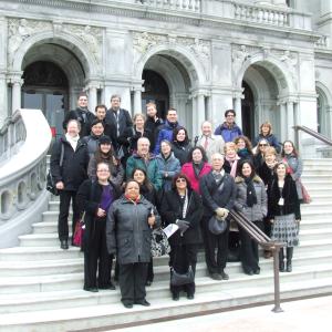 Group shot of faculty standing on the steps of the entrance to the Library of Congress