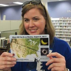 Lisa Nickel holding a map of the path of the eclipse