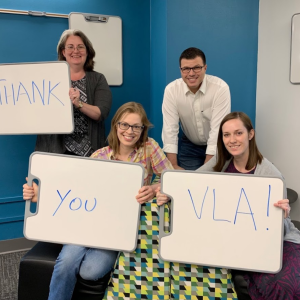 Liz Bellamy and colleagues holding signs that read "Thank you VLA!"