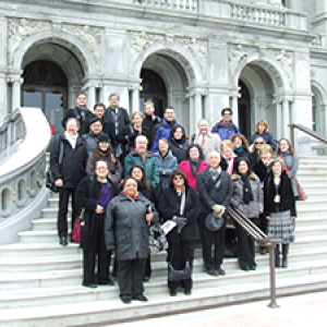 Group shot of faculty standing on the steps of the entrance to the Library of Congress