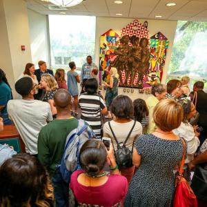 A crowd gathers in the Swem Lobby for the unveiling of the Lemonade mural