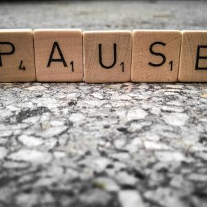 The word Pause spelled with Scrabble tiles
