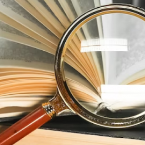 books with magnifying glass